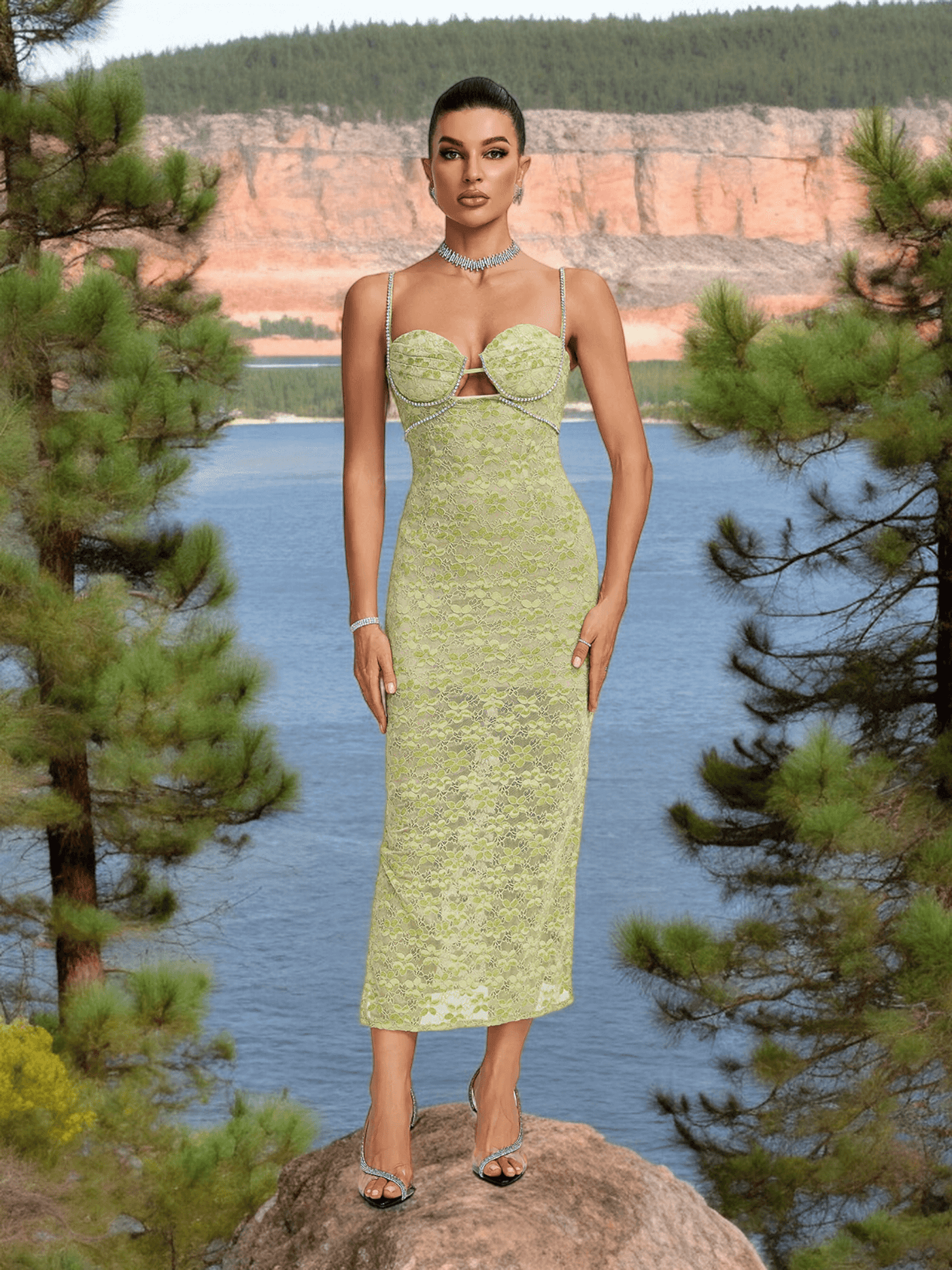 Model wearing Crystal Bustier Lace Midi Dress in Green, standing in front of a scenic lake and mountain background