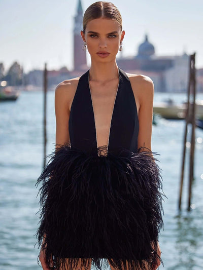 "Black halter dress adorned with crystals and feather accents."