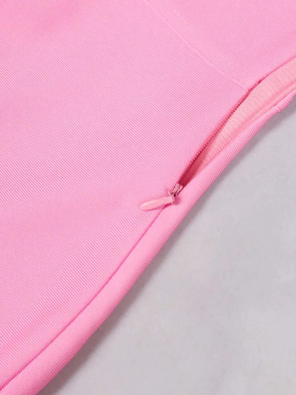 Close-up of pink one shoulder feather midi dress showing back zipper and material texture