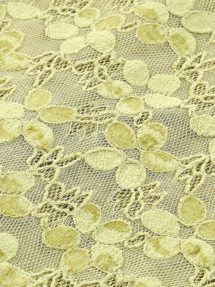 Close-up view of green lace fabric from the Crystal Bustier Lace Midi Dress Green with intricate floral patterns.