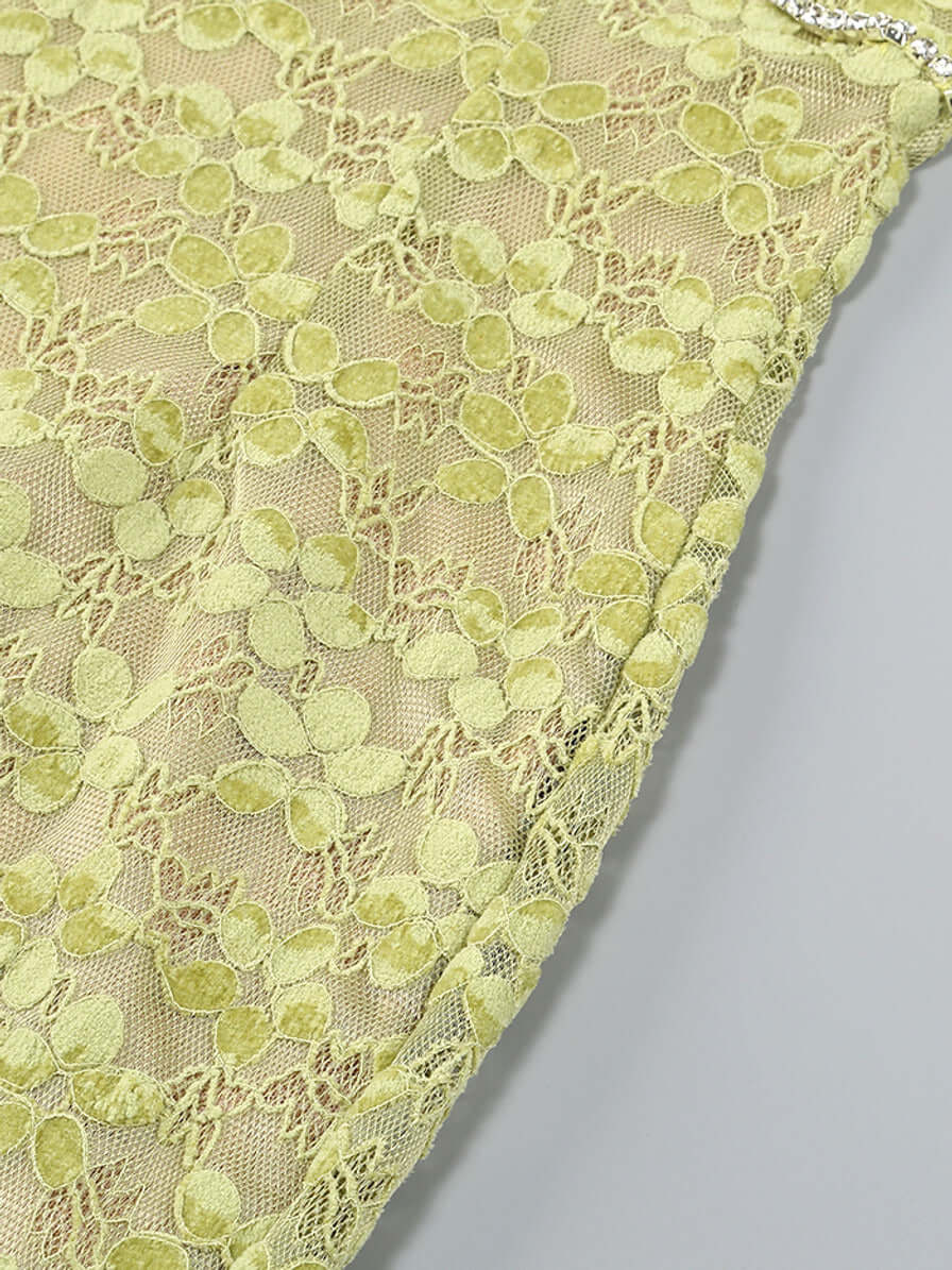 Close-up of green lace fabric on the Crystal Bustier Lace Midi Dress, highlighting intricate floral patterns and crystal detailing