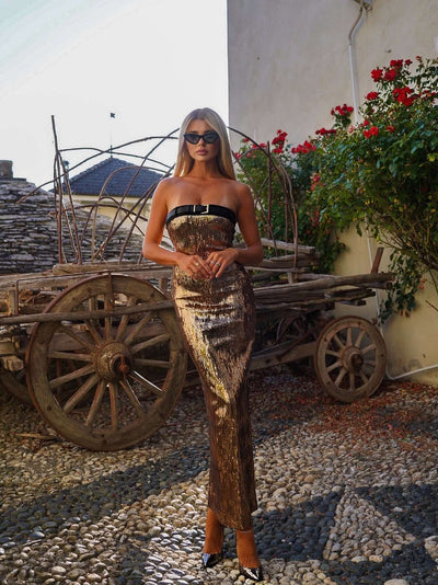 Stunning gold sequin maxi dress accentuated with a matching belt for added elegance.