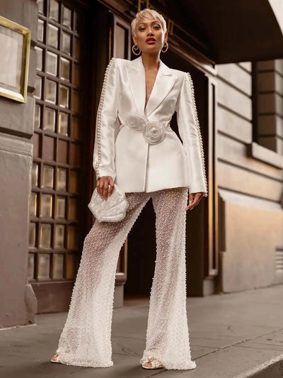 Sophisticated suit featuring a long-sleeved blazer adorned with 3D flowers, paired with trousers embellished with pearls for a stylish ensemble