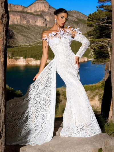 Beadwork Feather Maxi Dress in White with intricate detailing, showcased in a scenic outdoor setting.