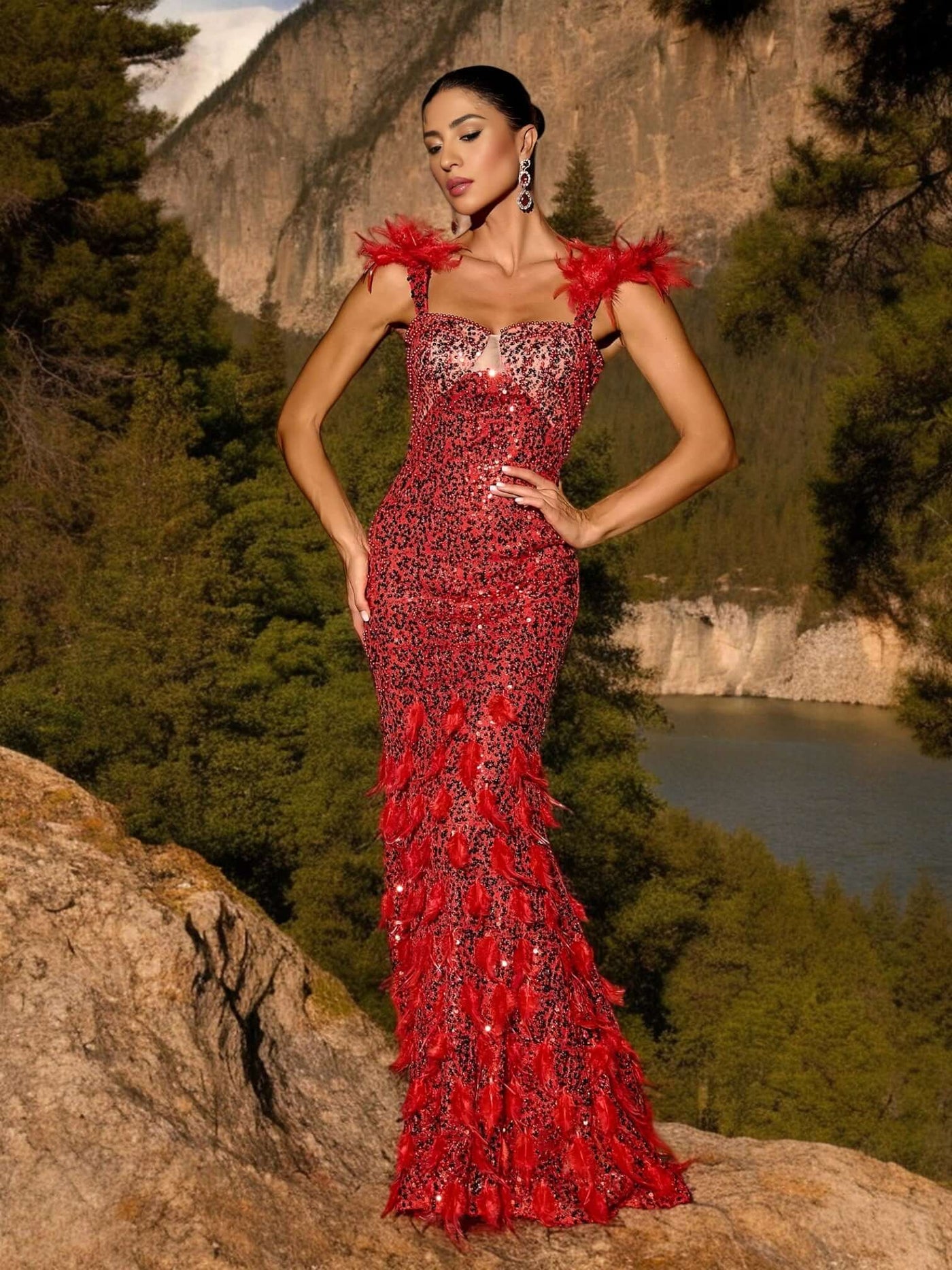 Model wearing Red Glitter Sequins Maxi Dress by Valensia Seven, posing in outdoor nature setting with forest and mountain background.